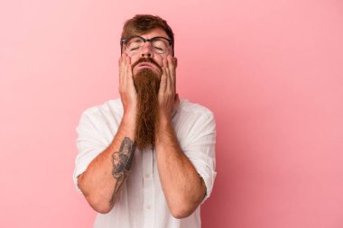 Uzun sakallı, beyaz tenli genç adam pembe arka planda inliyor ve ağlıyordu..