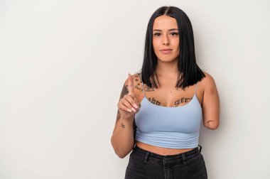 Beyaz arka planda tek kollu, beyaz tenli genç beyaz bir kadın, bir numarayı parmağıyla gösteriyor..