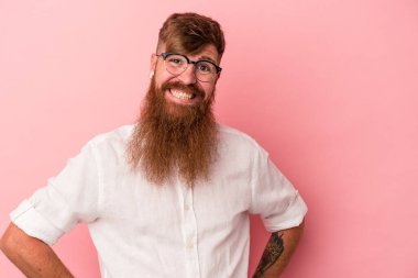 Uzun sakallı, beyaz, genç bir adam pembe arka planda izole edilmiş mutlu, güler yüzlü ve neşeli..