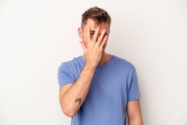 Pembe arka planda izole edilmiş genç beyaz adam hoş bir sürpriz alıyor, heyecanlı ve el kaldırıyor..