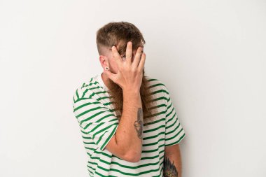 Beyaz arka planda uzun sakallı, beyaz tenli beyaz bir adam korkmuş ve gergin parmaklarıyla göz kırp..