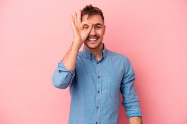 Pembe arka planda izole edilmiş genç beyaz adam heyecanlı..