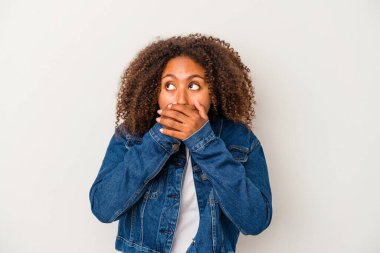 Beyaz arka planda izole edilmiş kıvırcık saçlı, genç Afrikalı Amerikalı kadın. Ağzını eliyle kapatan bir fotokopi odasına bakıyor..