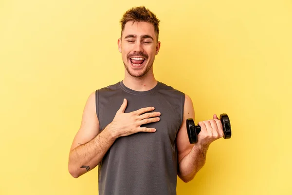 Jonge Sportman Met Een Halter Geïsoleerd Gele Achtergrond Lacht Luid — Stockfoto