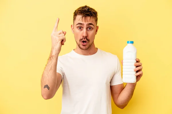 Jonge Blanke Man Met Een Fles Mil Geïsoleerd Gele Achtergrond — Stockfoto
