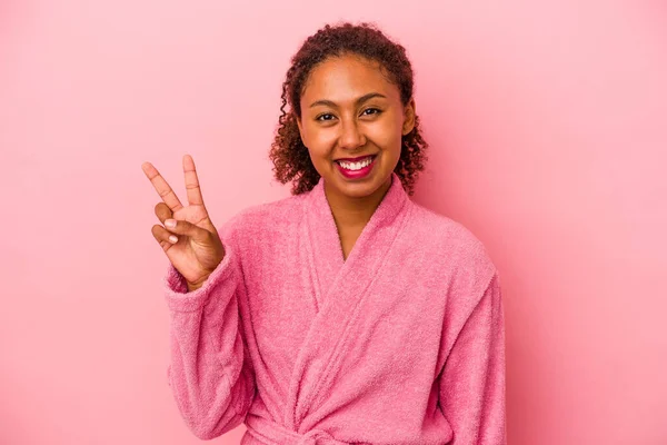 身穿浴衣的年轻非洲裔美国女人 背景粉红 快乐无忧无虑 手握和平象征 — 图库照片