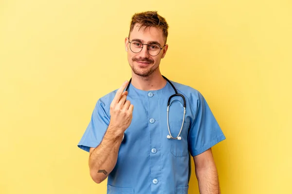 Jonge Verpleegster Blanke Man Geïsoleerd Gele Achtergrond Wijzend Met Vinger — Stockfoto
