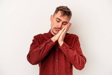 Beyaz arka planda izole edilmiş genç beyaz adam gülümsüyor, parmaklarını ağıza doğrultuyor..