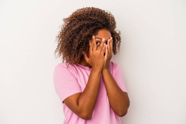 Beyaz arka planda izole edilmiş kıvırcık saçlı, genç Afro-Amerikalı kadın korkmuş ve gergin parmaklarıyla göz kırpıyor..