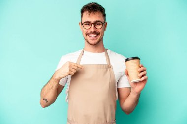 Elinde mavi arka planda kahve tutan genç tezgahtar gömleğin fotokopi alanını elle işaret ediyor, gururlu ve kendinden emin.