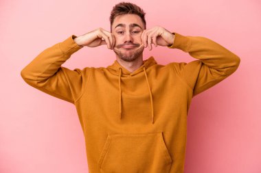 Pembe arka planda izole edilmiş beyaz bir adam iki seçenek arasında şüphe duyuyor..