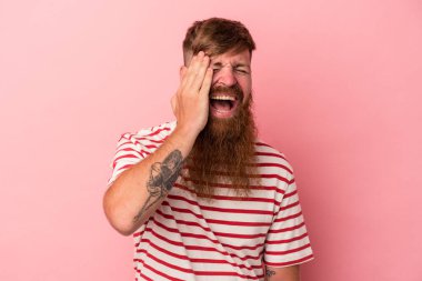 Uzun sakallı, pembe arka planda yalnız, gülen, kaygısız, doğal duyguları olan beyaz, genç bir adam..