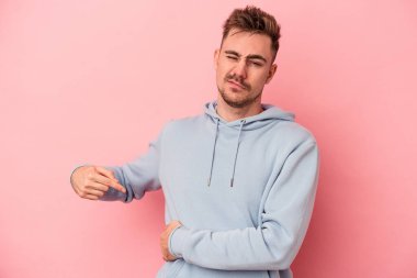 Pembe arka planda karaciğer ağrısı çeken, karnı ağrıyan genç beyaz bir adam..