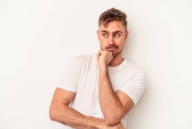 Beyaz arka planda izole edilmiş beyaz tenli genç bir adam palmiyesinde bir kopya alanı tutuyor..