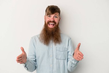 Beyaz arka planda uzun sakallı beyaz tenli genç beyaz adam iki eliyle bir şey tutuyor..