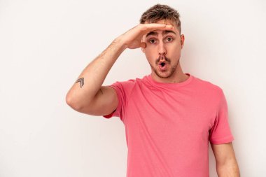 Beyaz arka planda izole edilmiş genç beyaz bir adam zaferi, tutkuyu ve coşkuyu kutluyor, mutlu bir ifade..