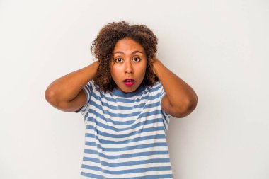 Beyaz arka planda yalıtılmış kıvırcık saçlı, elleri kulaklarıyla yüksek ses duymamaya çalışan Afro-Amerikalı genç bir kadın..