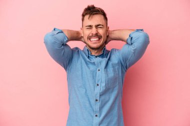 Pembe arka planda izole edilmiş genç beyaz adam öfkeyle bağırıyor..