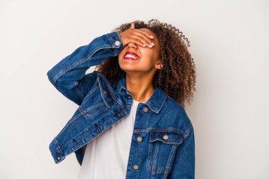 Beyaz arka planda yalıtılmış kıvırcık saçlı, genç Afro-Amerikalı kadın ellerini başının üstünde tutarak gülüyor. Mutluluk kavramı.