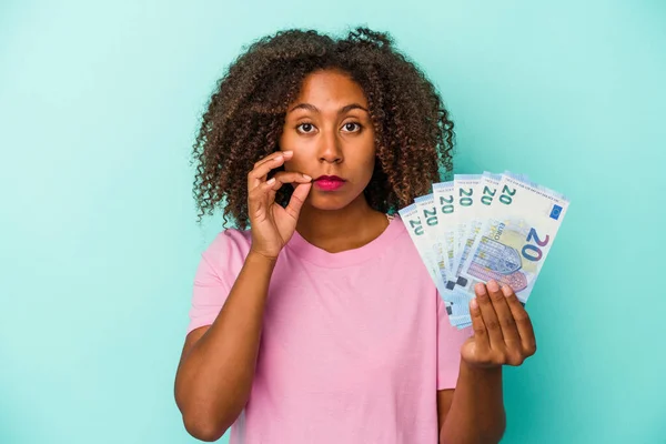 Mujer Afroamericana Joven Sosteniendo Billetes Euros Aislados Sobre Fondo Azul —  Fotos de Stock
