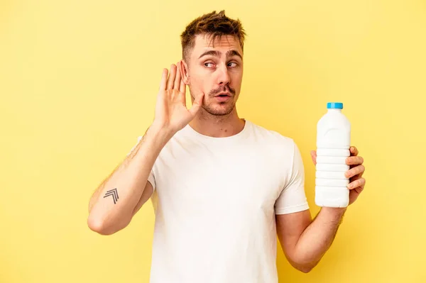 Jonge Blanke Man Met Een Fles Mil Geïsoleerd Gele Achtergrond — Stockfoto