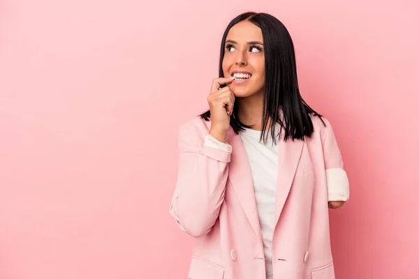 Young caucasian woman with one arm isolated on pink background relaxed thinking about something looking at a copy space.