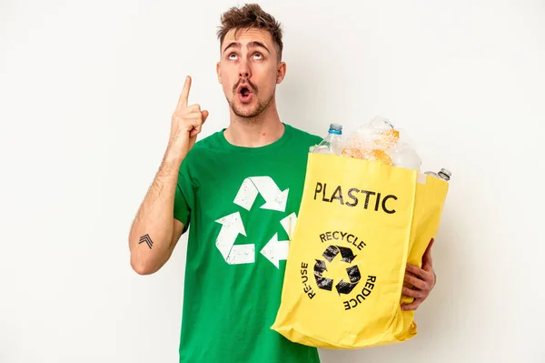 Jonge Kaukasische Man Gerecycled Plastic Geïsoleerd Witte Achtergrond Wijzend Ondersteboven — Stockfoto