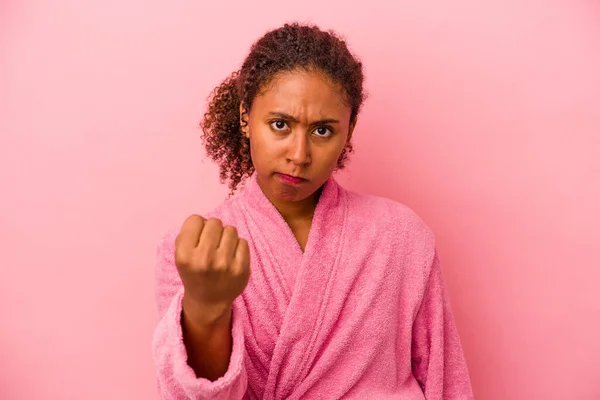 身穿浴衣的年轻的非洲裔美国女人 背景是粉色的 对着镜头 脸上带着咄咄逼人的表情 — 图库照片