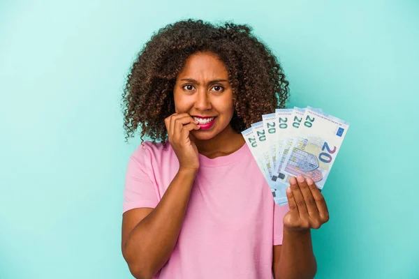 Joven Mujer Afroamericana Sosteniendo Billetes Euros Aislados Sobre Fondo Azul —  Fotos de Stock