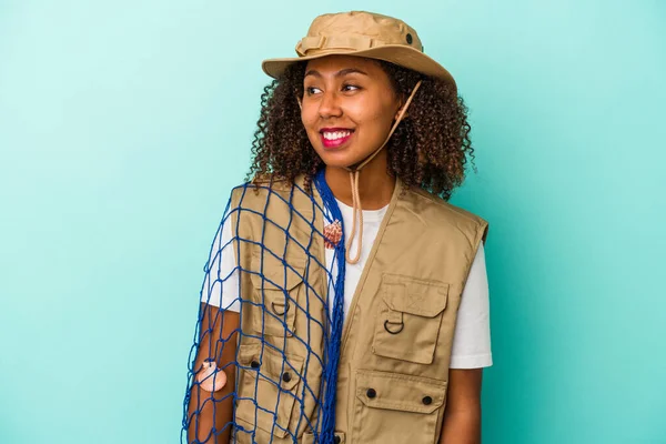 Young African American Fisherwoman Holding Net Isolated Blue Background Looks — Stock Photo, Image