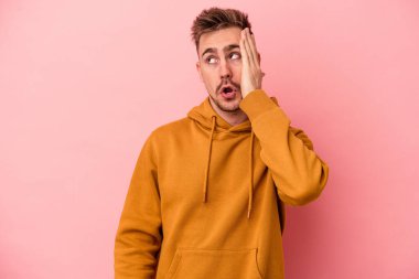 Pembe arka planda izole edilmiş genç beyaz adam şok geçiriyordu, önemli bir buluşmayı hatırladı..