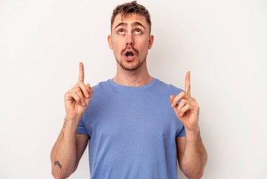 Beyaz arka planda izole edilmiş genç beyaz adam gördüğü bir şey yüzünden şoka uğruyor..