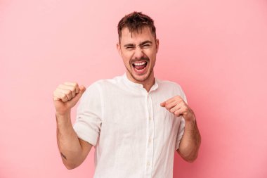 Genç beyaz adam pembe arka planda izole edilmiş dans ediyor ve eğleniyor..