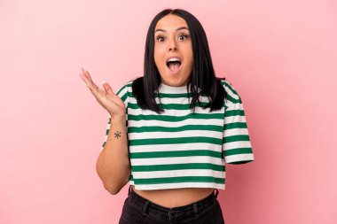 Tek kollu beyaz bir kadın pembe arka planda izole edilmiş, şaşırmış ve şok olmuş..