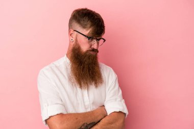 Pembe arka planda uzun sakallı, beyaz tenli genç adam tekrarlanan bir görevden yoruldu..