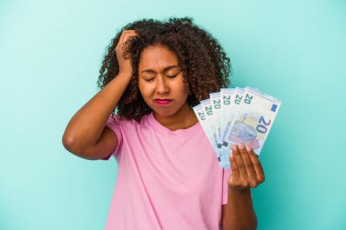 Avro banknotlarını elinde tutan genç Afrikalı Amerikalı kadın mavi arka planda izole edilmiş, şok olmuştu, önemli bir toplantıyı hatırladı..