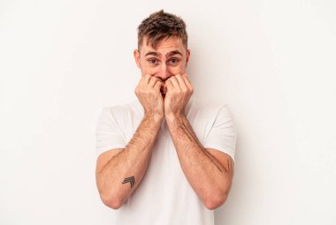 Beyaz arka planda izole edilmiş genç beyaz bir adam şüpheli ve şüpheci bir ifadeyle yana bakıyor..