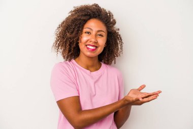 Beyaz arka planda izole edilmiş kıvırcık saçlı, genç Afro-Amerikalı bir kadın. Elinde palmiye ağacında bir kopyası var..