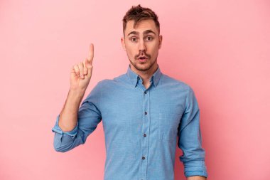 Pembe arka planda soyutlanmış genç beyaz bir adam. Harika bir fikri var, yaratıcılık kavramı..