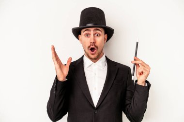 Beyaz arka planda izole edilmiş bir değnek tutan Kafkas büyücüsü şaşırdı ve şok oldu..