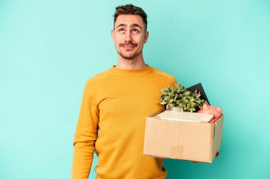 Kafkasyalı genç adam mavi arka planda hedeflerine ve amaçlarına ulaşma hayali kurarak hareket ediyor.