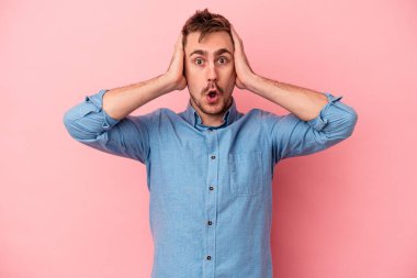 Pembe arka planda izole edilmiş genç beyaz adam şok geçiriyordu, önemli bir buluşmayı hatırladı..