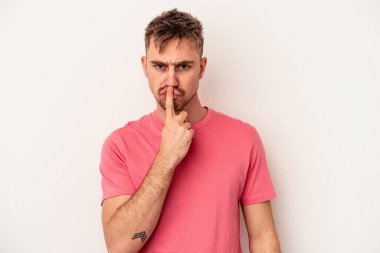 Beyaz arka planda izole edilmiş genç beyaz bir adam güçlü bir hareket gösteriyor, kollarıyla, kadınsı gücün sembolü.