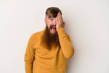 Beyaz arka planda uzun sakallı beyaz tenli genç beyaz adam yüzünün yarısını palmiye ile kaplayarak eğleniyor..