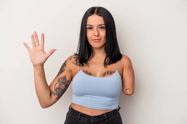 Beyaz arka planda tek kollu beyaz bir kadın gülümseyerek beş numarayı parmaklarıyla gösteriyor..