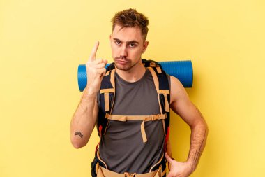 Genç yürüyüşçü beyaz adam sarı arka planda izole edilmiş bir fikir, ilham konsepti var..