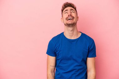 Pembe arka planda izole edilmiş genç beyaz adam çok kızgın, öfkeli, hayal kırıklığına uğramış diye bağırıyor..