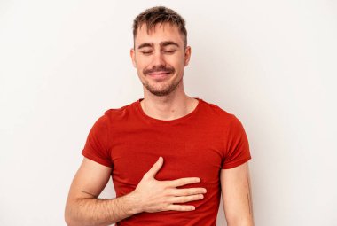 Beyaz arka planda izole edilmiş genç beyaz bir adam gözlerinde sorun olmadığını gösteriyor.