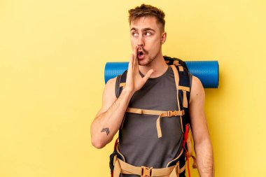 Sarı arka planda izole edilmiş genç beyaz adam gizli bir sıcak fren haberi veriyor ve yana bakıyor.