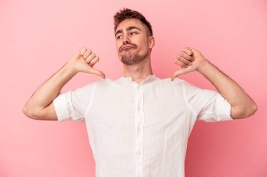 Pembe arka planda izole edilmiş genç beyaz adam gururlu ve kendinden emin hissediyor, örnek olarak.